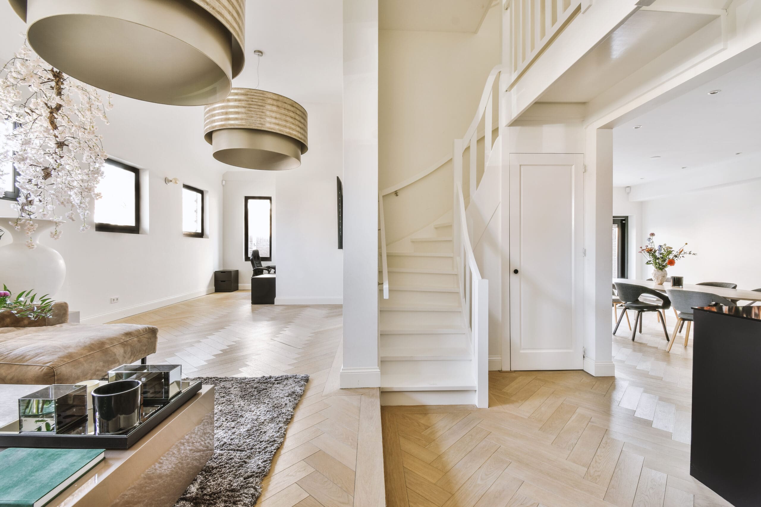 Vitmålad trappa i ljus hall med ekparkett och modern inredning